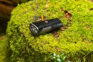 Sigma Buster 1600 mountain bike front light. Sigma Buster 1600 mountain bike front light resting on a moss-covered log.