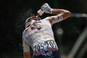 CYCLING-TDF-2026-STAGE 3 TotalEnergies team's French rider Thibault Guernalec douses himself with water to cool down as he cycles during the 3rd stage of the 113th edition of the Tour de France cycling race, 195,9 km between Granollers in Spain and Les Angles in southern France, on July 6, 2026. (Photo by Loic VENANCE / AFP via Getty Images)