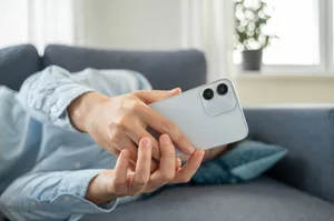 Tired Woman lying down on sofa after work Tired Woman in blue shirt lying down on sofa after work, using smartphone. Fake dummy phone