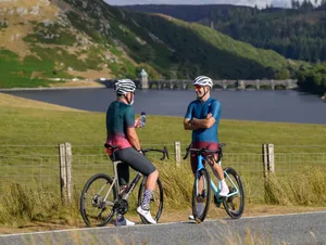 Two cyclists chatting during a break from riding a bike Two cyclists chatting during a break from riding a bike