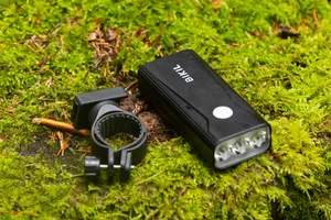 Bikil 2400 front light and handlebar mount Bikil 2400 mountain bike front light and black handlebar mount resting on moss.