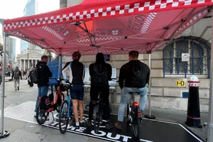HUlWUZZW4AA-b7g People standing under City of London police gazebo.