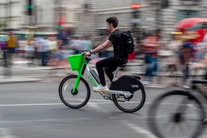 GettyImages-1493292720 Man riding Lime bike.