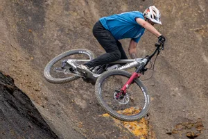 Atherton S.170E.2 boosting a rocky lip Rider jumps the silver Atherton S.170E.2 from a steep rocky lip on a mountain-bike trail