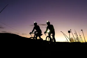 cycling-at-night Two cyclists silhouetted while cycling at night.