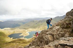 Two females hiking together in mountainous terrain Hiking up mountain for Three Peaks Challenge