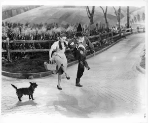 Judy Garland And Ray Bolger In ‘The Wizard Of Oz’ Actors Judy Garland and Ray Bolger dance in character on the 'Yellow Brick Road' as dog dog 'Toto' watches, in a scene from the film 'The Wizard Of Oz', 1939. (Photo by Metro-Goldwyn-Mayer/Getty Images)
