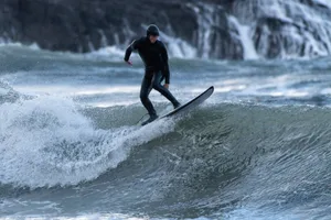 GettyImages-1300503338 (1) Man surfing on a beach in South Wales