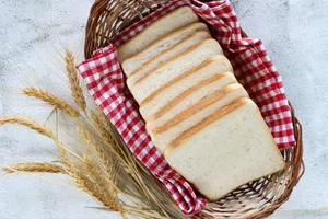 Image of a basketful of sliced white bread loaf/loaves – ultra processed food/UPF for convenient, ready-to-eat meals A basket full of white bread slices
