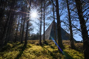 Giant Stone Pyramid – Balmoral, Scotland Giant stone pyramid on a sunny day with trees in foreground