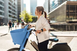 Young Asian woman riding electric bike in the city A woman pushing an electric bike