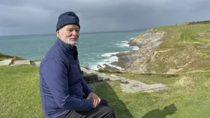 534780 Bill Murray sat on a cliff face looking at the camera