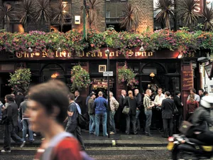 England, London, crowds in front of pub, pedestrian in foreground, blurred motion People stood outside of a pub drinking together