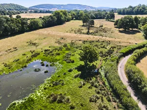 Aerial view of wetlands at Holnicote, where beavers have raised groundwater level creating full ponds and retaining moisture in the soils. Credit National Trust Images Steve Sayers The Holnicote site seen from above with greenery surrounded by drought land
