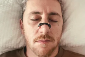 snorer Man wearing magnetic nasal strip.