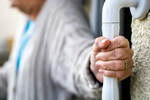 fall-common A close-up of the hands of an elderly person holding onto a bar for support
