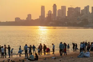 India-warming Late afternoon view of locals, commonly known as "Mumbaikars," on Chowpatty Beach, a popular city beach and perfect location to watch the sunset over Back Bay in India