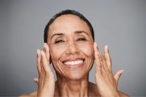Face A woman touches her faces with her hands.