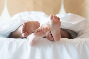 Sexual frequency (2) Two pairs of feet sticking out the end of a bed