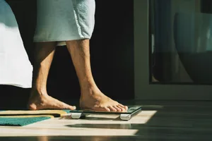 foot stepping on scales Person stepping on scales.