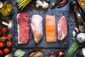 Raw meat and fish Cuts of raw meat and fish lined up on a slate serving platter.