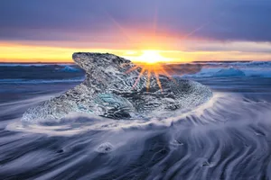 Ice on horizone Big icy rock in the sea with a sunset background