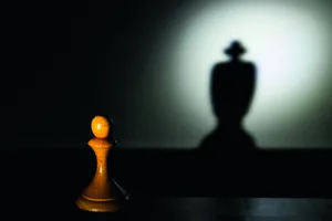 money-corrupts Photo of a pawn chess piece in the light, its shadow is that of the queen or king
