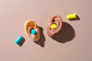 Earbuds Two realistic models of ears with brightly coloured earbuds in and next to them