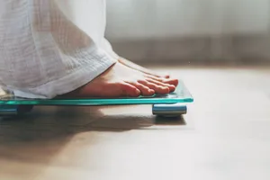 Weight A pair of feet standing on weighing scales