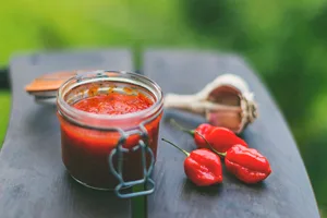 Chilis A collection of chili peppers next to a spicy sauce