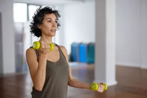 Woman in gym A woman doing a dumbbell workout in the gym