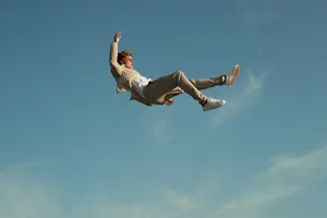 Gravity lost Man in suit floats into the blue sky