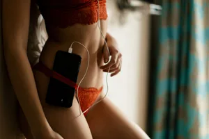 National Orgasm Day A woman wearing red underwear is listening to music playing from her mobile phone
