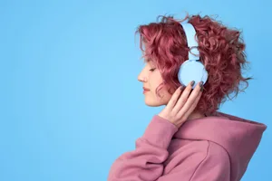 Songs that reduce anxiety A woman wearing headphones against a blue background