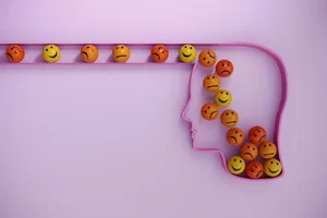 5 things you should never say to someone with ADHD Colourful balls with happy and unhappy faces rolling into an outline of a human head