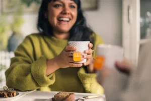 What herbal tea should you be drinking A woman drinking a herbal tea and smiling