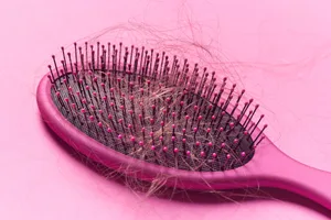 A pink hair brush against a pink background A pink hair brush against a pink background