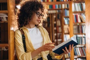 Main image A woman reading a book in a bookshop