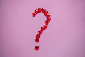 Red hearts arranged in the shape of a question mark on a pink background Red hearts arranged in the shape of a question mark on a pink background