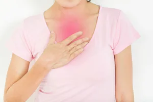 oesophagitis A woman touching her chest, with the area highlighted in pink to represent heartburn