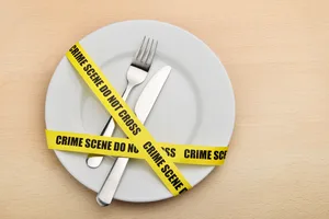 Dangerous food Dangerous food. Empty plate, fork and knife wrapped in crime scene tape