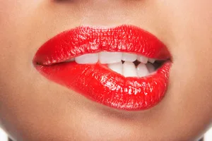 Sexting A woman wearing red lipstick is biting her lip