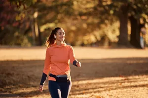 How far do you need to walk to be healthy A woman walking in an autumnal park
