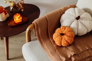 Affordable autumn updates Two bouclé pumpkin cushions on a chair