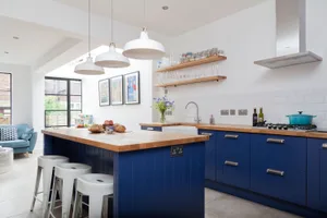 Kitchen makeover: ‘Our kitchen is now a multifunctional space’ Deep blue units add a dramatic dash of colour against the dazzling white walls