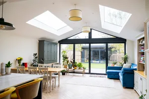 herringbone-floor-header Interior of open plan living space in modern home extension with large patio doors to garden.