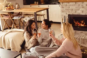 Koselig Three friends drinking wine in a cosy home