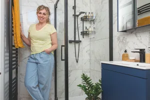 Scandi bathroom makeover Female homeowner stands in her en suite bathroom after its Scandi makeover