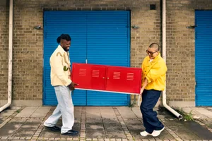 ikea-marketplace Two people carry a red sideboard