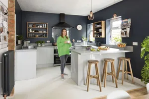 Three-room open-plan kitchen makeover The dark walls and copper accessories add glamour
to the functional kitchen space, while the bespoke open shelves allow the deep blue paint to shine through.